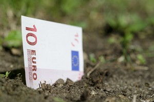 Banknote of ten euro coming up from the ground